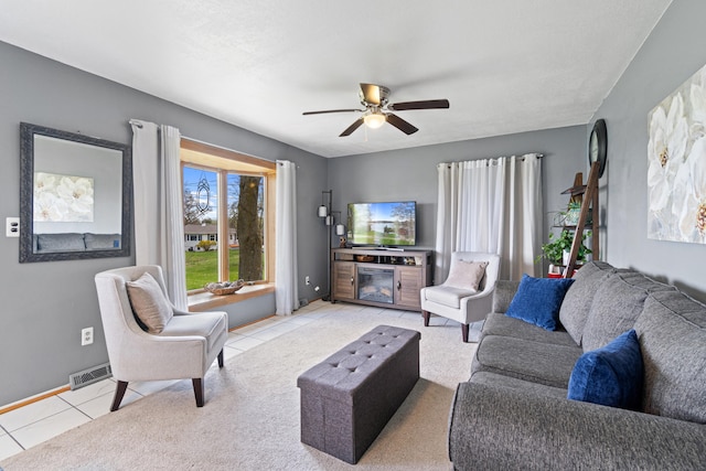 living area with a ceiling fan, baseboards, visible vents, and light tile patterned floors