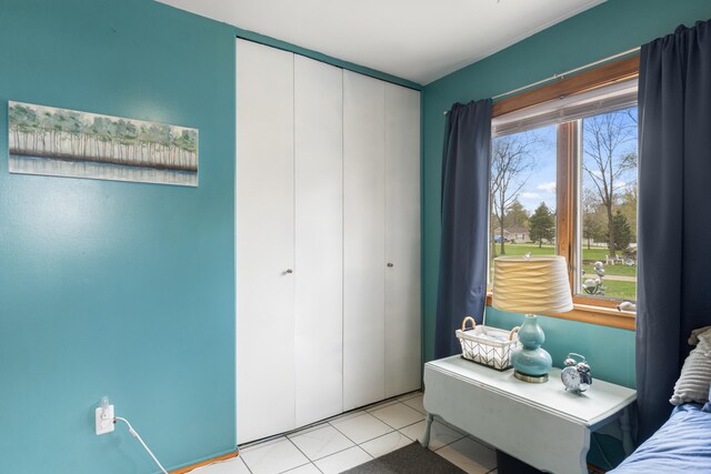 bedroom with light tile patterned flooring and a closet