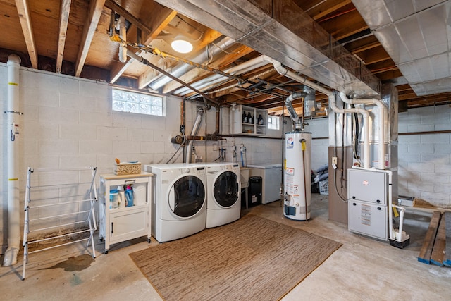clothes washing area featuring laundry area, washer and clothes dryer, heating unit, and gas water heater