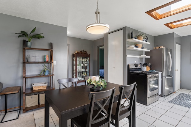 dining area featuring light tile patterned flooring and a skylight
