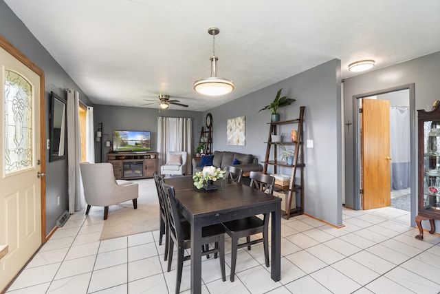 dining area featuring light tile patterned floors, baseboards, ceiling fan, and a wealth of natural light