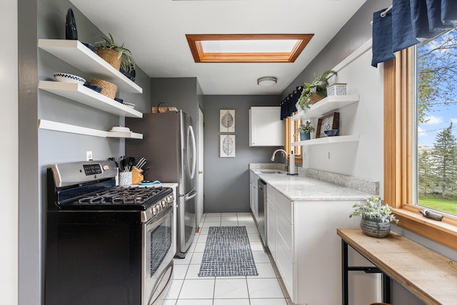 kitchen with open shelves, light countertops, white cabinetry, a sink, and stainless steel appliances