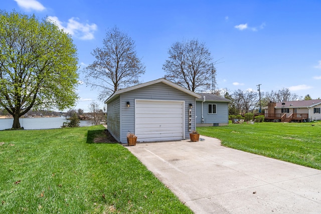 detached garage featuring a water view and concrete driveway