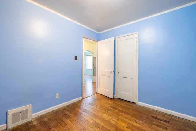 19302 Moross Rd, Detroit, MI 48224 - unfurnished bedroom featuring wood-type flooring, baseboards, and crown molding