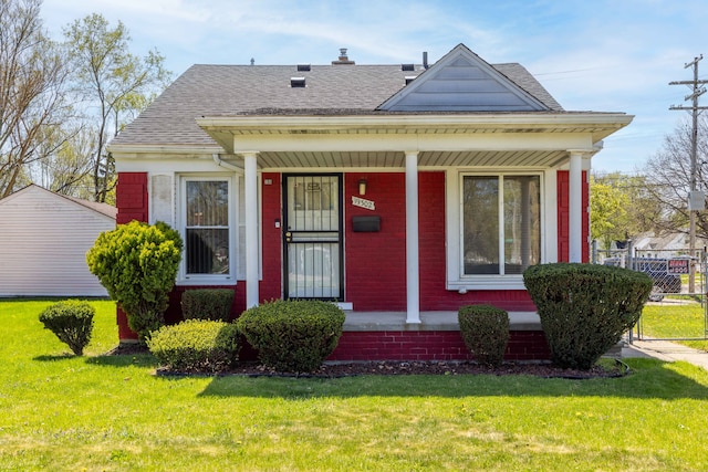 19302 Moross Rd, Detroit, MI 48224 - view of front of house with brick siding, a front yard, covered porch, and roof with shingles
