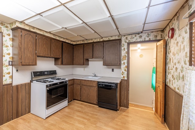 19302 Moross Rd, Detroit, MI 48224 - kitchen featuring white gas range oven, black dishwasher, wallpapered walls, light wood-style floors, and light countertops