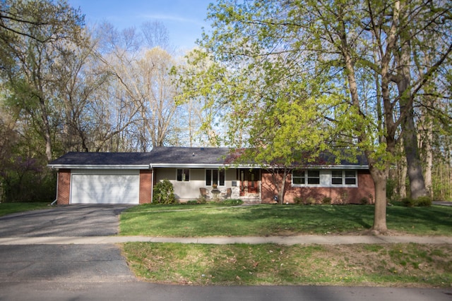 ranch-style house with a garage, a front yard, driveway, and brick siding
