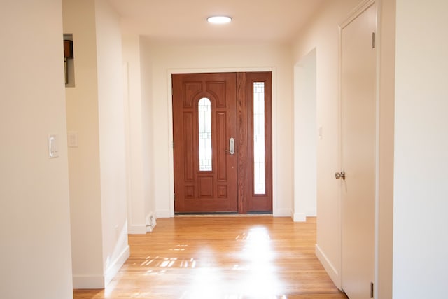 foyer featuring baseboards and light wood-style floors