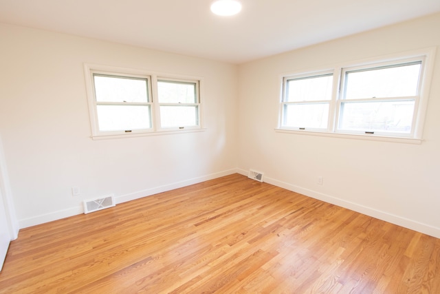 unfurnished room with baseboards and visible vents