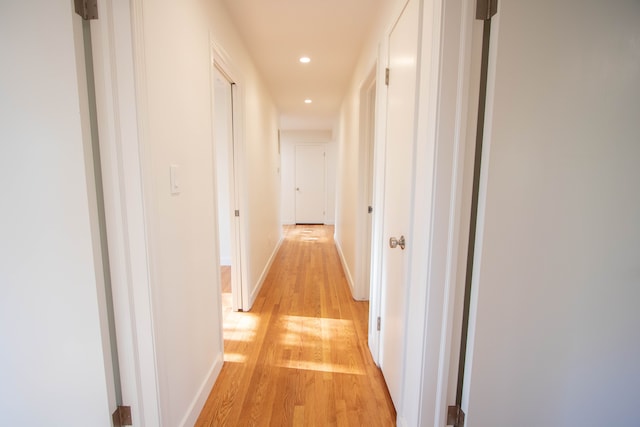 hallway featuring recessed lighting, baseboards, and light wood-style floors
