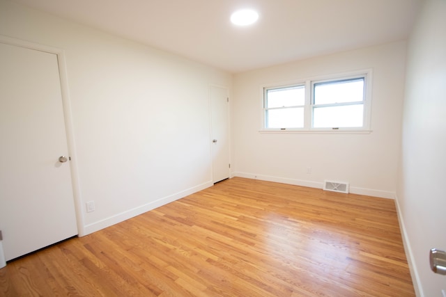 spare room featuring baseboards, visible vents, and light wood-style flooring