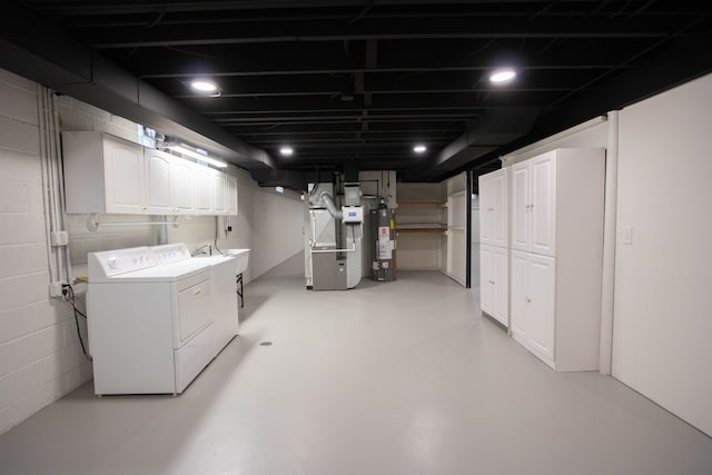 finished below grade area featuring independent washer and dryer, concrete block wall, heating unit, and water heater