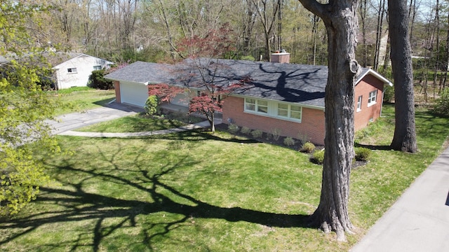 ranch-style house featuring an attached garage, driveway, a chimney, and a front yard