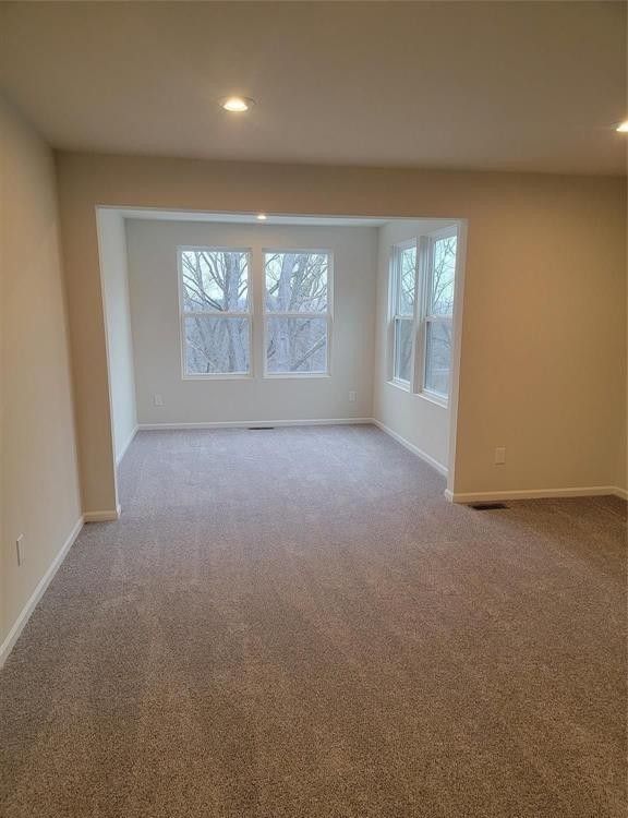 carpeted empty room featuring baseboards and recessed lighting