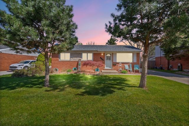 view of front facade with brick siding and a front yard