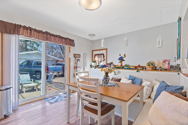 dining room with light wood finished floors and visible vents