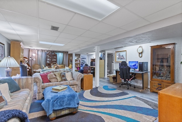 living room featuring visible vents, a paneled ceiling, and wood finished floors