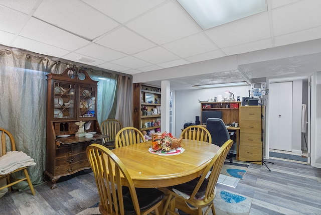 dining area featuring a drop ceiling, wood finished floors, and visible vents