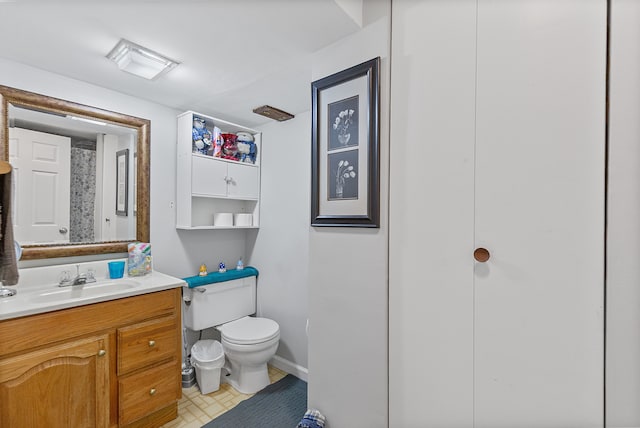 bathroom with vanity, baseboards, and toilet