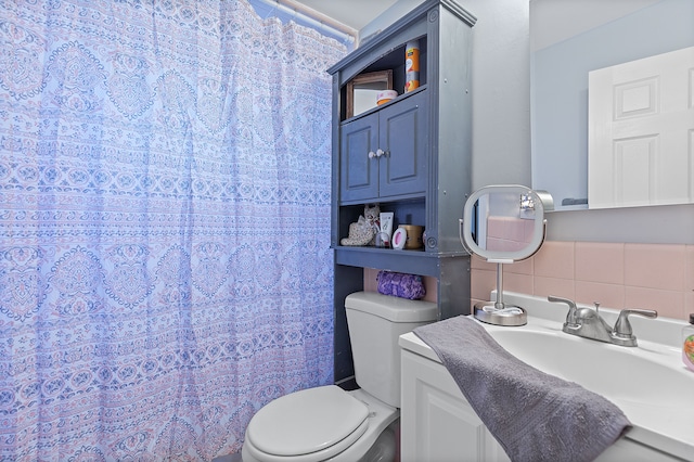 bathroom featuring a sink, curtained shower, and toilet