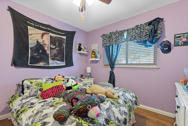 bedroom with baseboards and wood finished floors