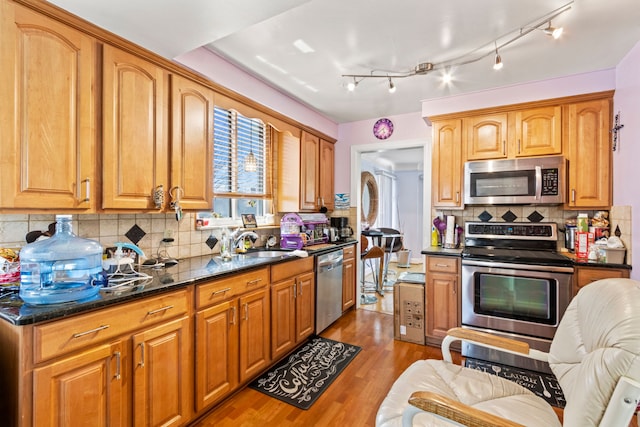 14174 Archdale St, Detroit, MI 48227 - kitchen with a sink, dark wood finished floors, dark stone counters, stainless steel appliances, and decorative backsplash