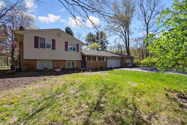 split level home with brick siding, a garage, a front yard, central air condition unit, and driveway