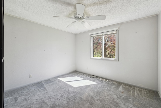 carpeted spare room with visible vents, a textured ceiling, and ceiling fan