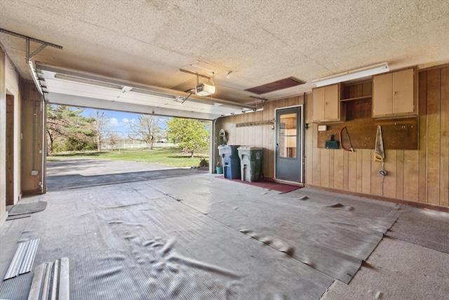garage with wooden walls and a garage door opener