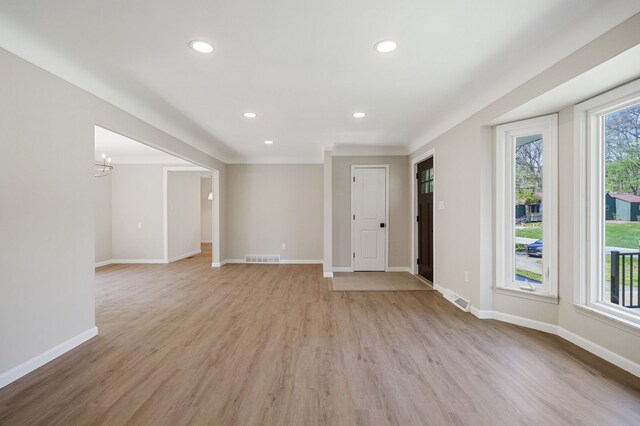 unfurnished living room featuring an inviting chandelier, visible vents, baseboards, light wood-style floors, and recessed lighting