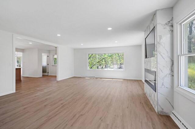 unfurnished living room featuring light wood-style floors, recessed lighting, and baseboard heating