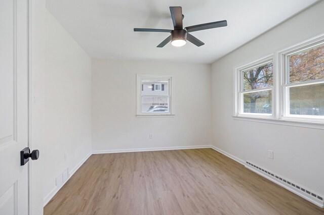 unfurnished room with visible vents, a ceiling fan, light wood-style floors, baseboards, and a baseboard radiator