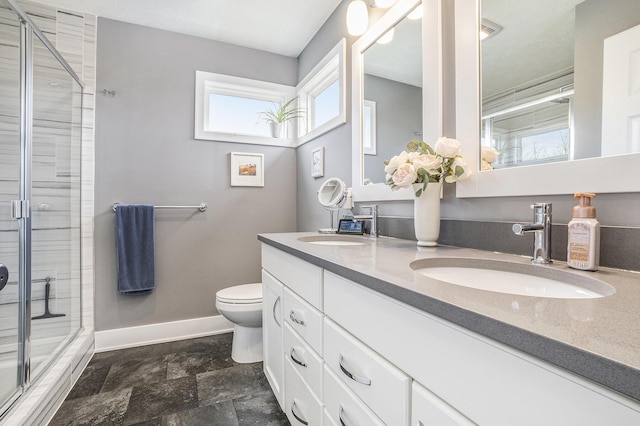 bathroom featuring baseboards, a sink, and a stall shower