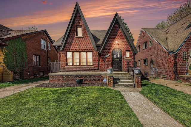 5279 E Somerset Ave, Detroit, MI 48224 - tudor house featuring a front lawn, brick siding, and roof with shingles