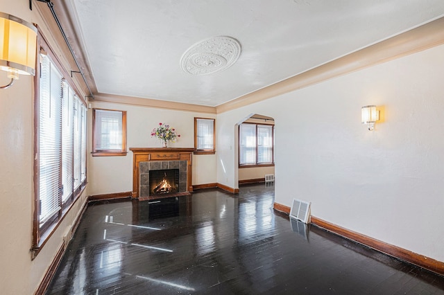 5279 E Somerset Ave, Detroit, MI 48224 - unfurnished living room with baseboards, arched walkways, a tile fireplace, and wood finished floors