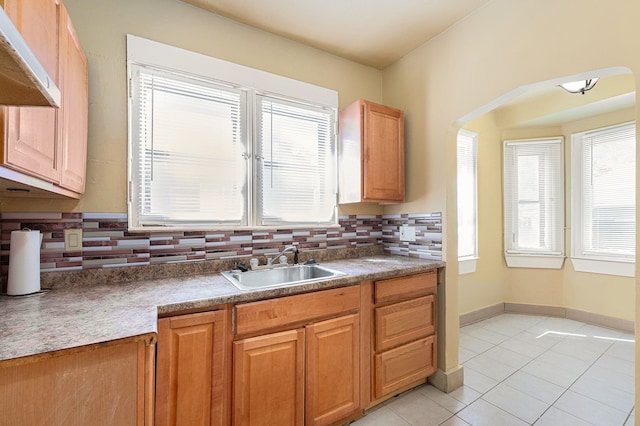 5279 E Somerset Ave, Detroit, MI 48224 - kitchen featuring a sink, tasteful backsplash, arched walkways, light tile patterned flooring, and under cabinet range hood