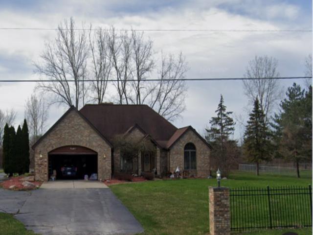 7407 Beecher Rd, Flint, MI 48532 - view of front of property with concrete driveway, a garage, and stone siding