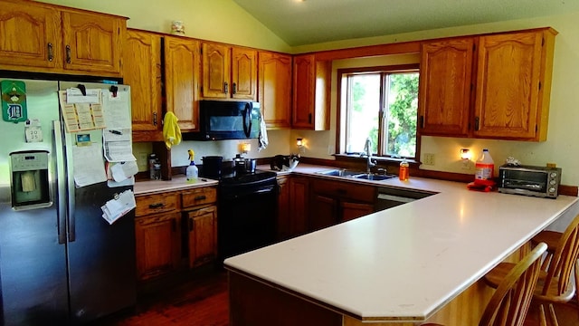 7407 Beecher Rd, Flint, MI 48532 - kitchen with black appliances, a peninsula, vaulted ceiling, brown cabinetry, and light countertops