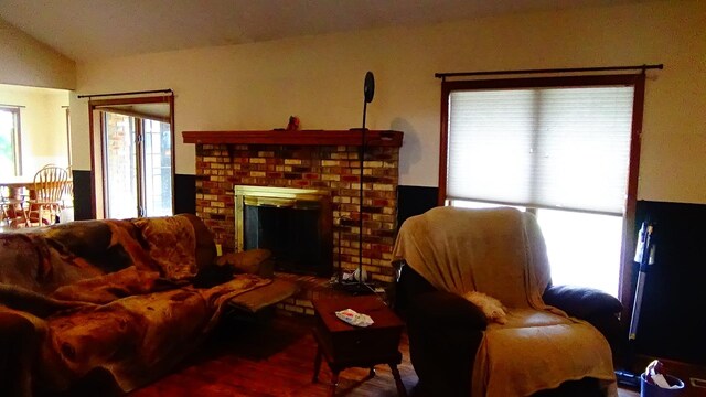 7407 Beecher Rd, Flint, MI 48532 - living room featuring a fireplace, wood finished floors, and lofted ceiling