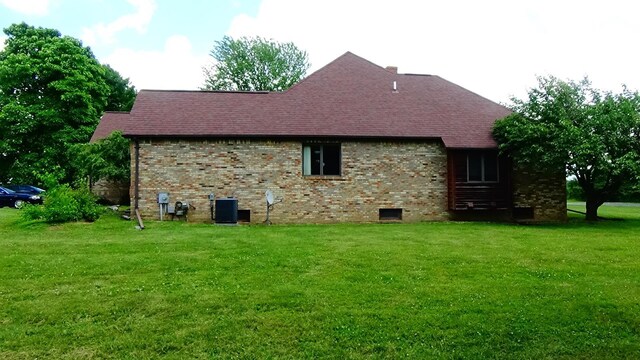 7407 Beecher Rd, Flint, MI 48532 - view of property exterior featuring a yard, a shingled roof, and brick siding