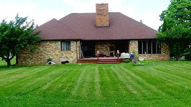 7407 Beecher Rd, Flint, MI 48532 - rear view of house featuring a chimney, a lawn, a wooden deck, and brick siding