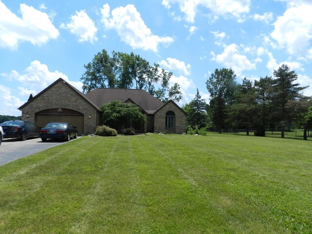 7407 Beecher Rd, Flint, MI 48532 - view of front of home featuring stone siding, an attached garage, and driveway