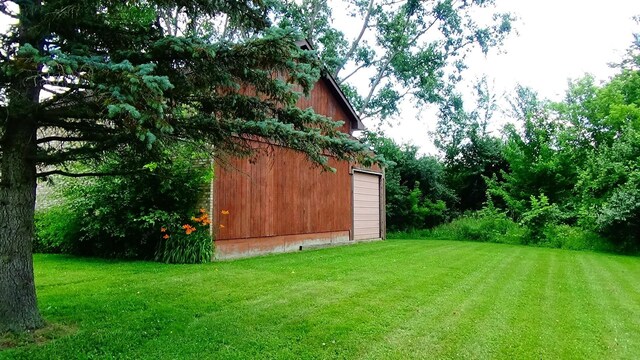 7407 Beecher Rd, Flint, MI 48532 - view of green lawn with an outbuilding and a detached garage