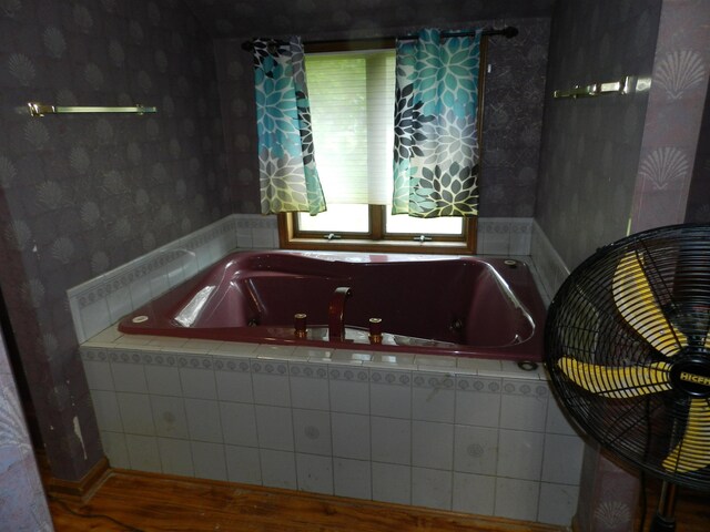 7407 Beecher Rd, Flint, MI 48532 - bathroom featuring wallpapered walls, a jetted tub, and wood finished floors