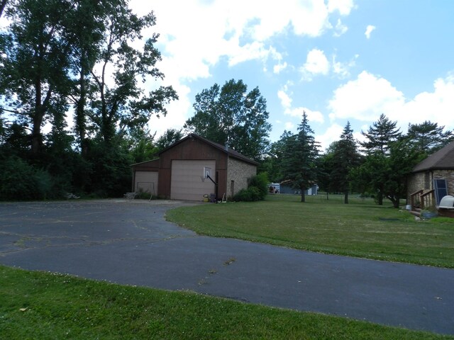 7407 Beecher Rd, Flint, MI 48532 - view of side of home featuring an outbuilding, a detached garage, and a yard