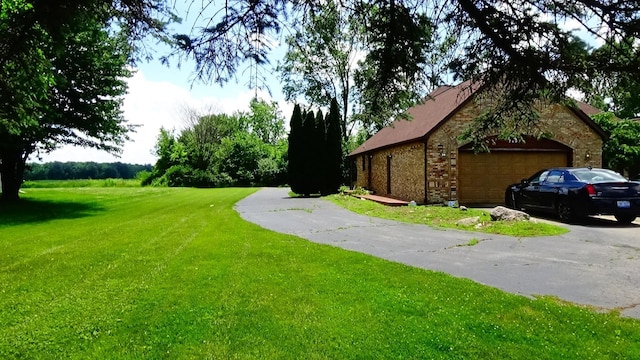 7407 Beecher Rd, Flint, MI 48532 - view of green lawn with a garage and asphalt driveway