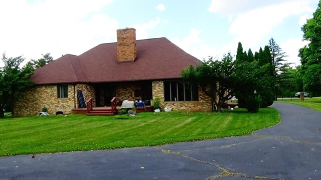 7407 Beecher Rd, Flint, MI 48532 - view of front of home with a front yard, a chimney, and brick siding
