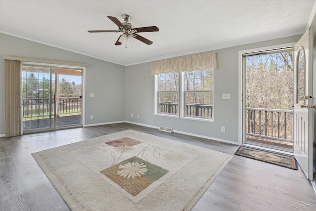 interior space featuring baseboards, a ceiling fan, vaulted ceiling, and a healthy amount of sunlight
