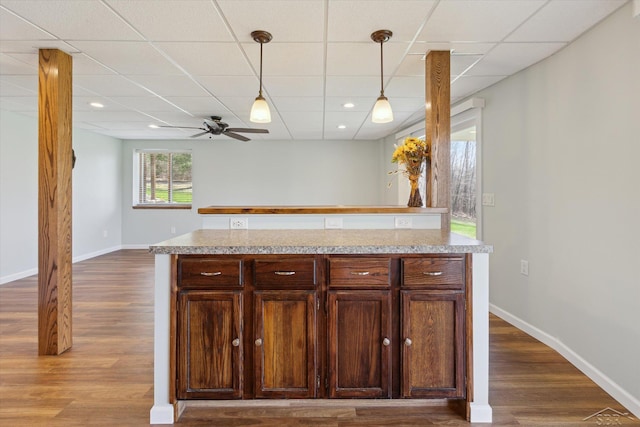 kitchen featuring light countertops, a ceiling fan, and a drop ceiling