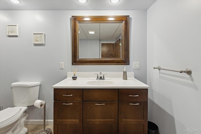 bathroom featuring vanity, baseboards, and toilet